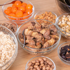 Rice dumpling zongzi making - wrapping Chinese rice dumpling zongzi on table at home for Dragon Boat Festival celebration, close up, lifestyle.