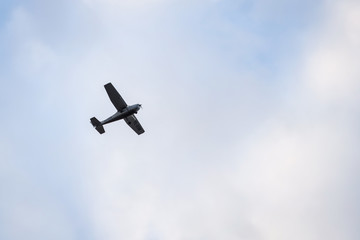 Small plane flying on the backgorund of clouds. Photo taken in cloudy day, Europe, Latvia.