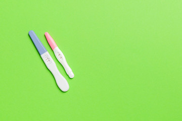 Colored Pregnancy test on colored background, top view with copy space