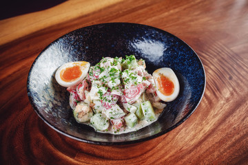 Vegetable salad with boiled eggs mixed with sour cream 