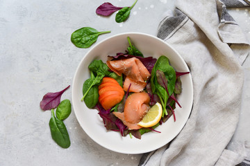 keto lunch salmon salad spinach, arugula, sesame and lemon. dish for a healthy lunch or dinner. menu healthy food delivery. Top view with copy space.
