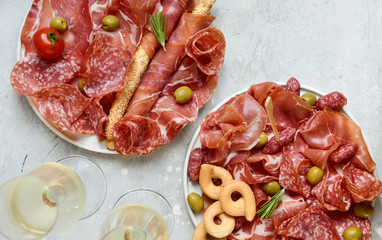 Obraz premium italian prosciutto, salami, bresaola olives tomatoes and grissini bread sticks. Aperitif in Italy in Florence, Rome, aperitif in Milan. Serving appetizers for an aperitif, lunch, dinner and holiday.