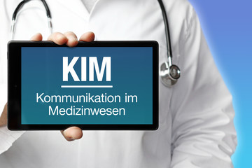 KIM (Kommunikation im Gesundheitswesen). Arzt hält einen Tablet Computer in die Kamera. Text auf...