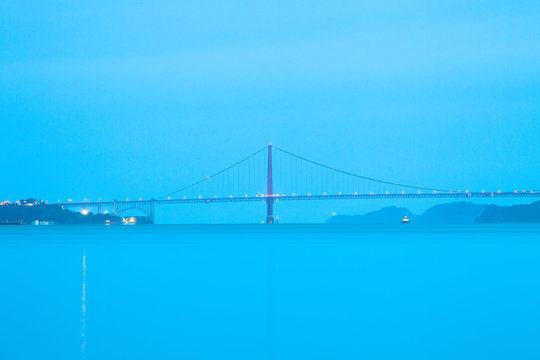 A side view of the Golden Gate Bridge at a blue dawn in San Francisco, California, United States