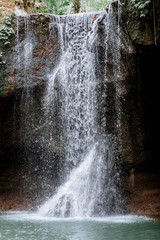 Amazing waterfall Suwat in Gianyar, Bali Indonesia, a stunning island. Jungle waterfall the best cascade in tropical rain forest with rock & turquoise blue pond.