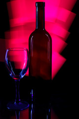 Crystal glass and a bottle of wine on a glass table