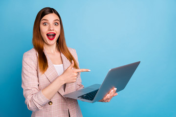 Portrait of excited shocked girl manager work home laptop point index finger screen impressed social media promotion wear plaid jacket isolated over blue color background