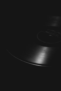 Vintage music vinyl record on the black background. Macro photo of vinyl record. Old school vinyl. Gramophone record listen. Image of music. Old music art. Old disc vinyl record isolated on black back