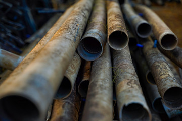 Old PVC water pipes with dust stacked in farm.