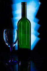 Crystal glass and a bottle of wine on a glass table