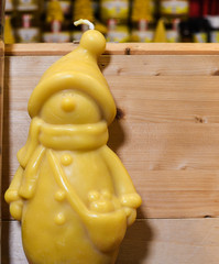 Beautiful hand made honey bee wax candle in form of a little boy or snow man at Christmas market.