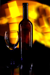 Crystal glass and a bottle of wine on a glass table