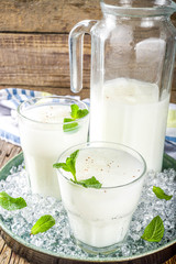 Cold Indian drink Lassi, iced coconut Lassi drink with mint leaf, wooden background copy space