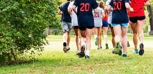 Rear view of a group of kids running together in a park