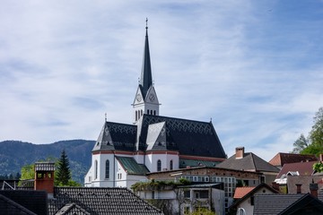 Fototapeta na wymiar Old white Saint Martin Church in Bled, Slovenia hidden behind buildings in this European city
