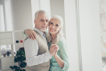 Close up photo of lovely old people looking dressed shirt brown turquoise pullovers standing in light apartment