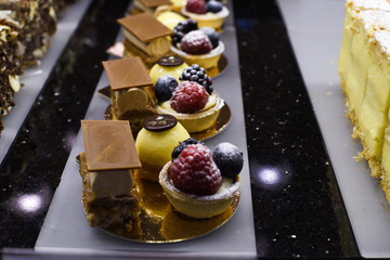 Various types of cakes, tart, mousse, pies for sale in bakery or pastry shop, gourmet luxury concept