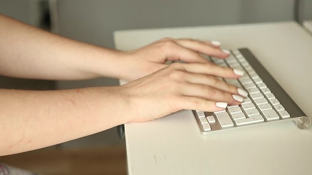 Woman&rsquo;s hand typing on white keyboard. Woman working at the computer. Office worker