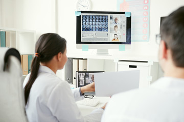 Obraz premium Group of doctors on computer monitor discussing x-ray images with colleagues during online conference
