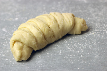 Raw homemade croissants on a gray table