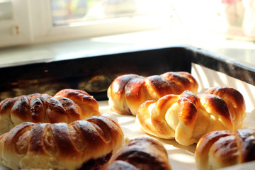 Homemade croissants in a baking sheet on the table near the window