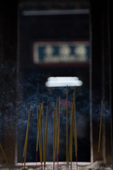 smoke yellow incense sticks in a Buddhist temple in a Vietnamese city