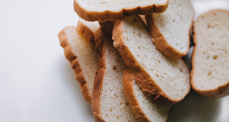 Scattered pieces of white dried bread lie on a white background. Photography, concept, copy space.