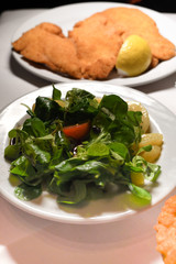 Wiener schnitzel, veal cutlet, austrian cuisine. Served with cold potatoes and rucola salad