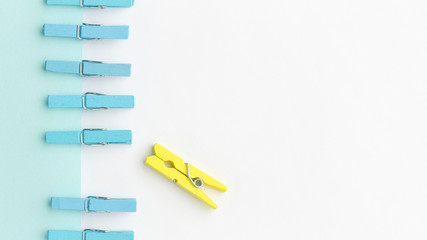Blue and yellow clothespin with copy-space. Outstanding, choice and difference concept. Being...