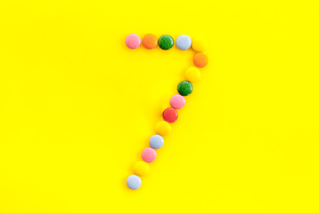 Candies font. Number 7 - seven - on yellow background top view
