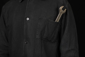 a spanner in the pocket of the mechanic's uniform