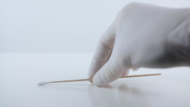 Placeing a swab for covid testing on a white surface.