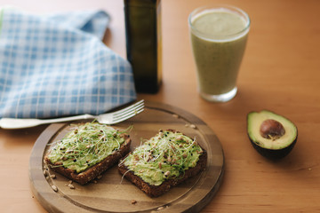 Fresh avocado and micro greens on toast - the perfect lunch or snack. Served with smoothie