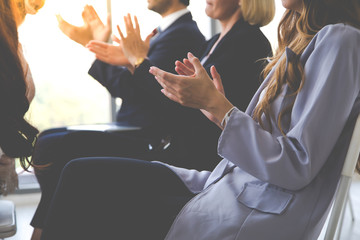 Smiling audience applauding at a business seminar. Multiethnic Business Team Meeting Seminar...