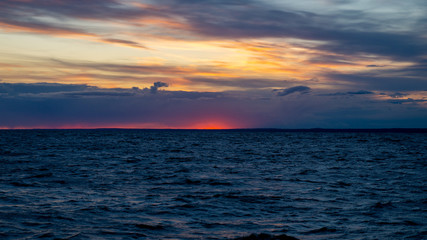 Sunset on the beach, dramatic sky and clouds.