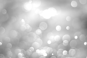 White glitter vintage lights background. White bokeh on black background.