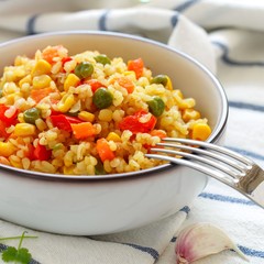 Bulgur with vegetables-onions, garlic, carrots, red bell peppers, green peas and corn. Healthy homemade organic vegan vegetarian diet food. Pilaf. useful lunch or dinner. Selective focus