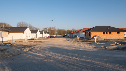 Newly built houses under construction. The newly built street is not yet paved.