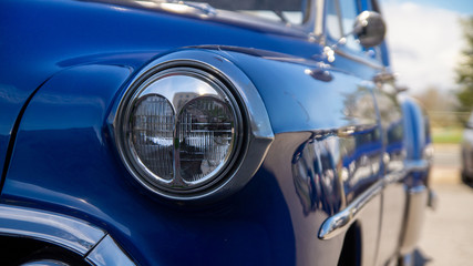 Obraz na płótnie Canvas Front light of a blue vintage Chevrolet