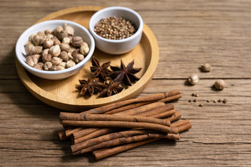 Variety of Thai and Indian spices and natural herbs supplements health food in bowl and spoon on rustic table with copy space.