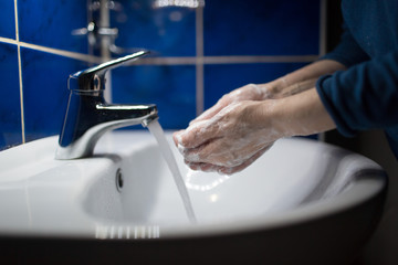 Woman washes hands with soap under water tap. Coronavirus prevention and washing. Pandemic COVID-19 Hygiene Rules.