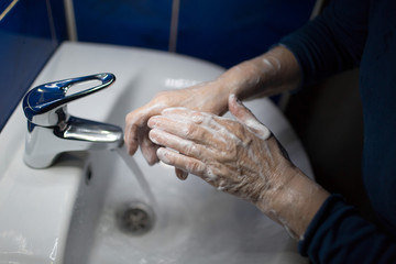 Woman washes hands with soap under water tap. Coronavirus prevention and washing. Pandemic COVID-19 Hygiene Rules.