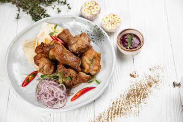 Grilling meat, sous and vegetables on white table