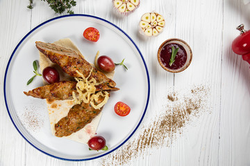 Grilling meat, sous and vegetables on white table