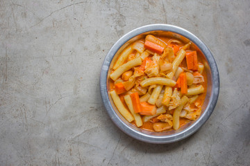 Korea's spicy rice cake, tteok-bokki stick on a plate. Famous Korean food is on a bowl. It is made by stir frying rice cake, red pepper sauce and vegetables.