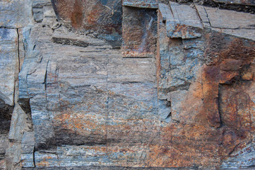 Fragment of a granite rock of gray and rusty tones