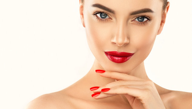 Beautiful girl showing red  manicure nails & lips. Woman Makeup, beauty and cosmetics