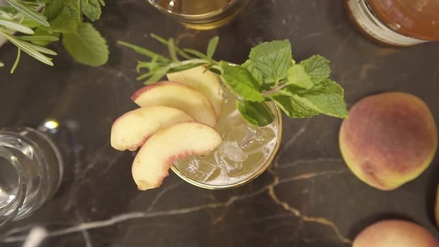 top view of drink with peaches and rosemary - rack focus