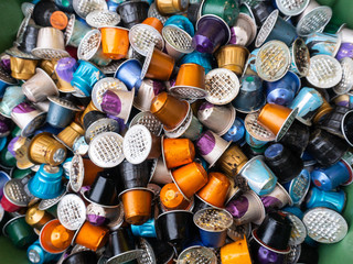 Used coffee capsules in many different colours in a disposal waste container.