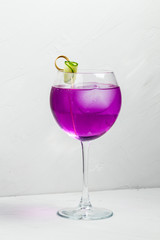 Unusual purple alcoholic cocktail in a wine glass